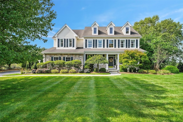 view of front facade featuring a porch, stone siding, and a front lawn