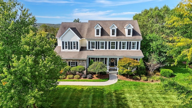 view of front of house with stone siding, a shingled roof, and a front lawn