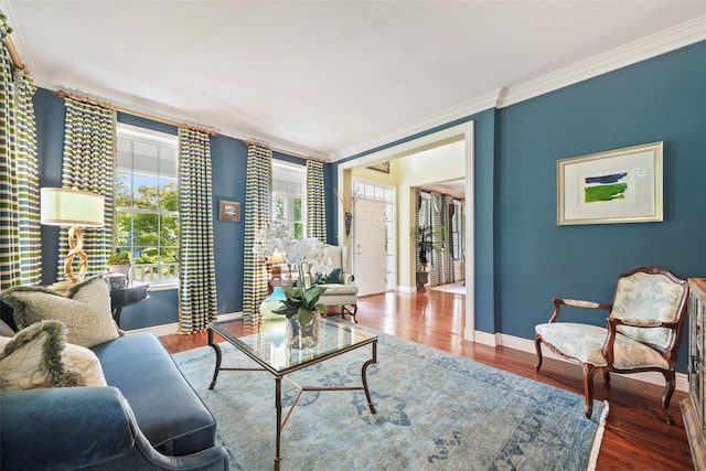 living room with baseboards, crown molding, and wood finished floors