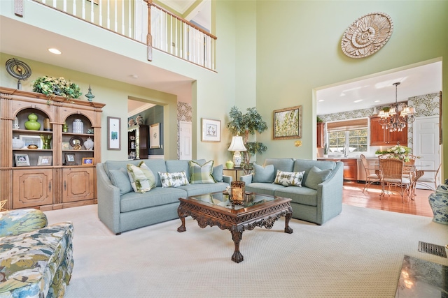 living room featuring light carpet, a high ceiling, a notable chandelier, and recessed lighting