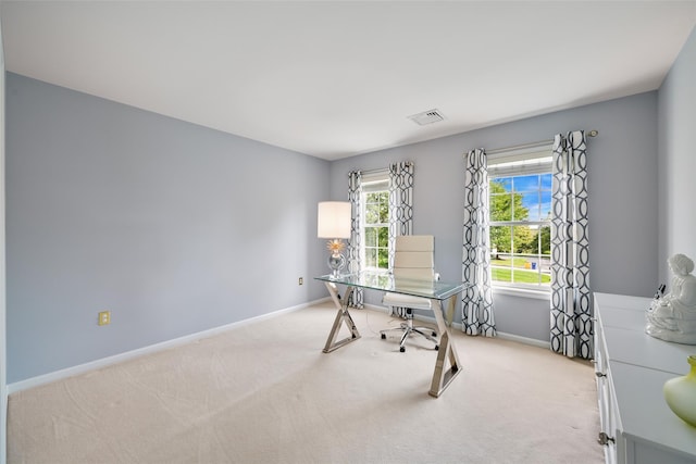 home office with light colored carpet, visible vents, and baseboards