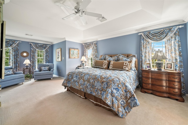 bedroom featuring a tray ceiling, carpet, visible vents, and crown molding