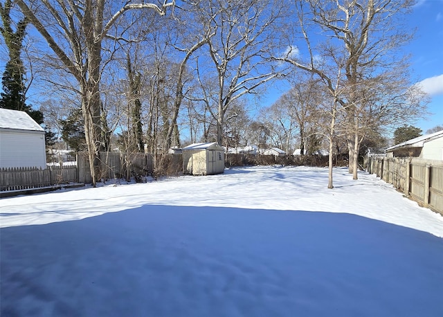 yard covered in snow featuring a storage shed