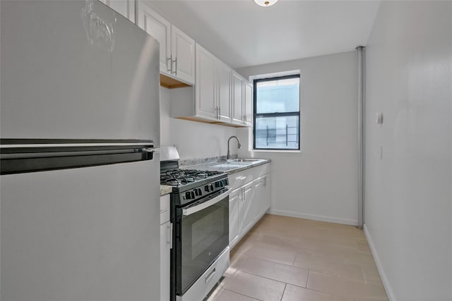 kitchen with white cabinetry, sink, light tile patterned floors, and stainless steel appliances