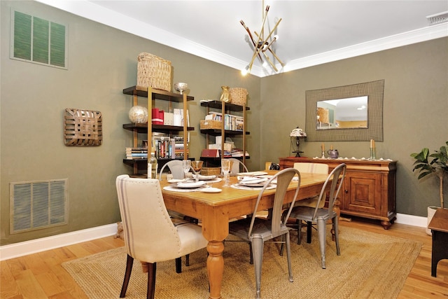 dining room featuring light hardwood / wood-style flooring and ornamental molding