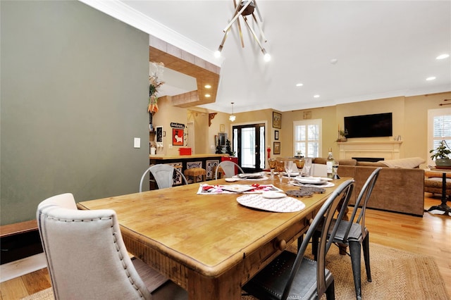 dining space featuring crown molding, plenty of natural light, and light wood-type flooring