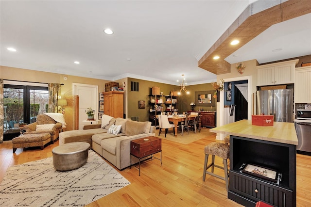 living room featuring ornamental molding and light wood-type flooring