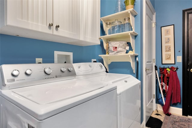 laundry room featuring washer and clothes dryer and cabinets