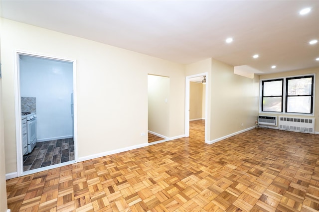 spare room with heating unit, radiator, and light parquet flooring