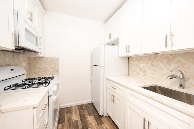 kitchen with light stone counters, white appliances, sink, and white cabinets