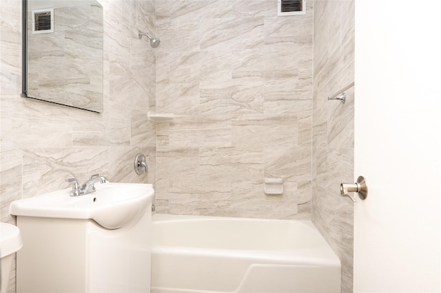 full bathroom featuring vanity, tiled shower / bath, and toilet