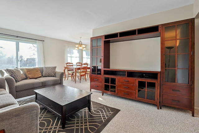 living area with light carpet and an inviting chandelier