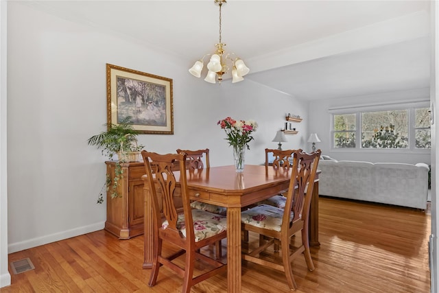 dining space featuring an inviting chandelier and light hardwood / wood-style flooring