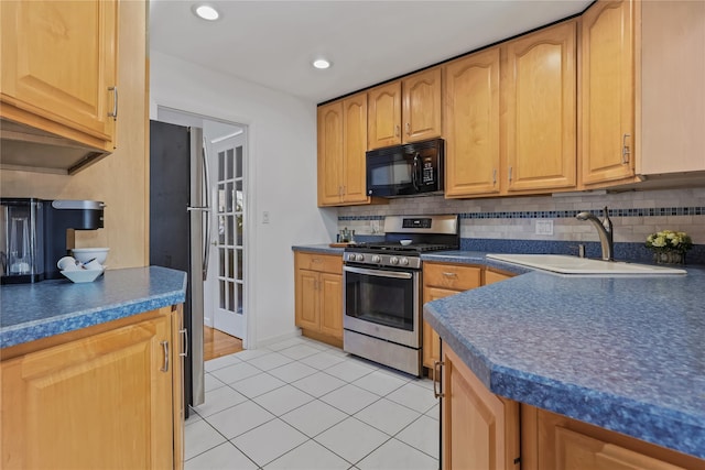 kitchen featuring tasteful backsplash, appliances with stainless steel finishes, sink, and light tile patterned floors