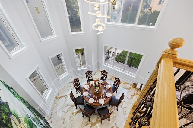 interior space with a towering ceiling, a wealth of natural light, and a notable chandelier