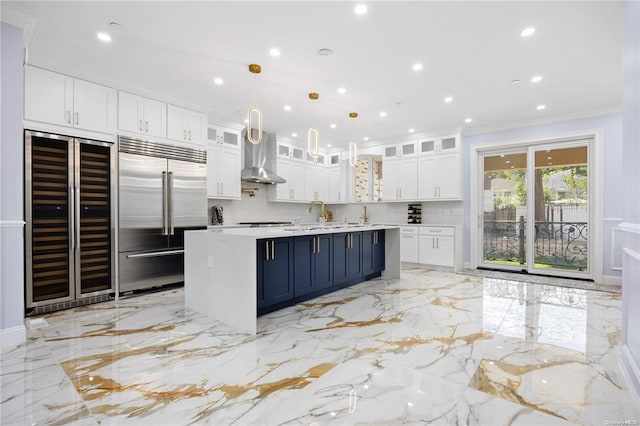 kitchen with blue cabinetry, a center island, built in fridge, pendant lighting, and white cabinets