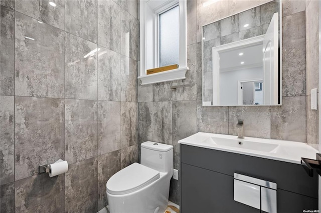 bathroom with vanity, toilet, and tile walls