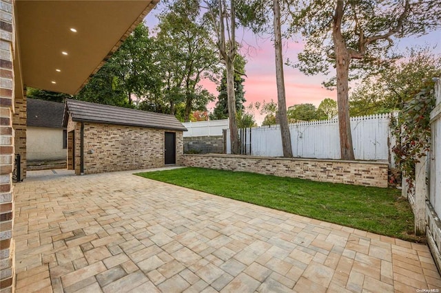 patio terrace at dusk featuring an outdoor structure