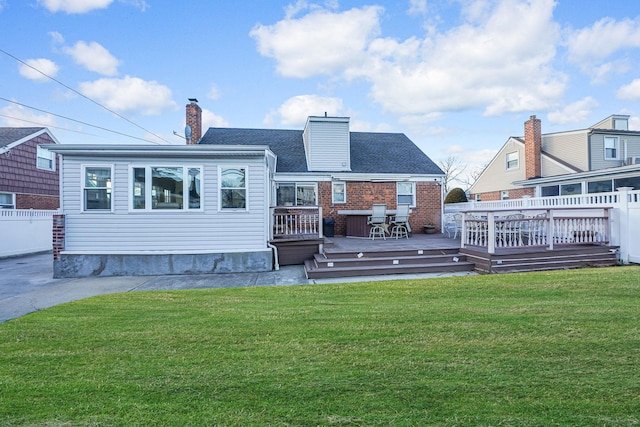 rear view of house with a yard and a deck