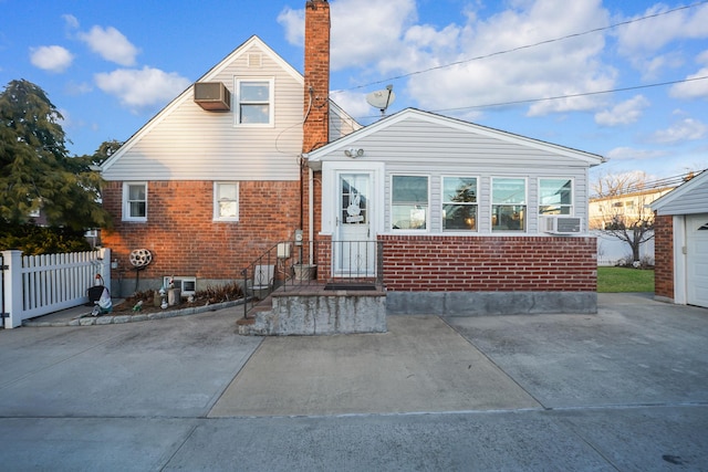 rear view of property with cooling unit and a wall mounted air conditioner