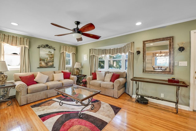 living room with crown molding, light hardwood / wood-style flooring, and ceiling fan