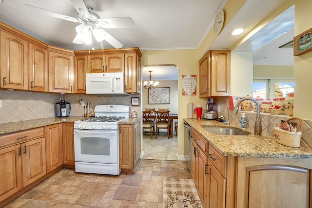 kitchen featuring light stone countertops, sink, backsplash, and white appliances