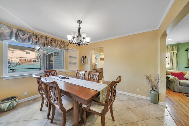 dining room featuring light tile patterned flooring, ornamental molding, and a notable chandelier