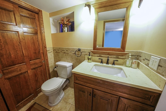 bathroom featuring vanity, tile patterned floors, tile walls, and toilet