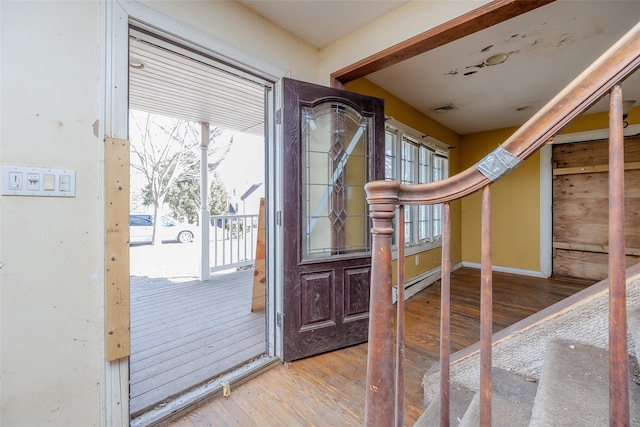 doorway with plenty of natural light, light hardwood / wood-style floors, and a baseboard heating unit