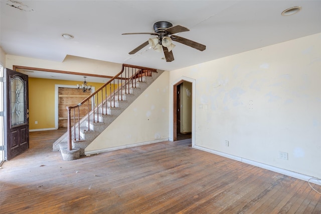 unfurnished living room featuring hardwood / wood-style flooring and ceiling fan with notable chandelier