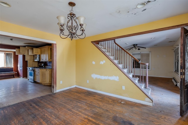 interior space with appliances with stainless steel finishes, dark hardwood / wood-style floors, ceiling fan with notable chandelier, and baseboard heating