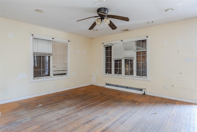 spare room featuring a baseboard heating unit, hardwood / wood-style flooring, and ceiling fan