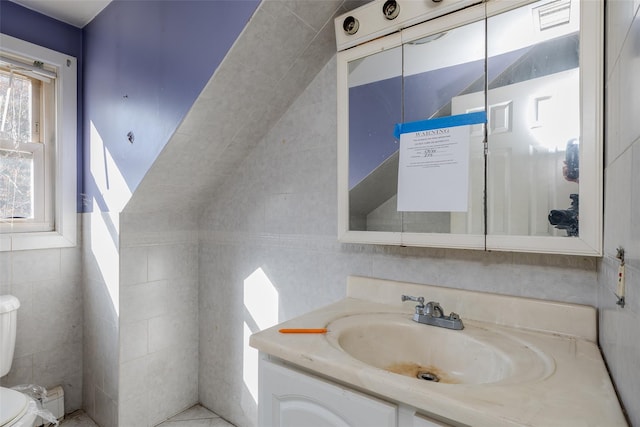 bathroom featuring vanity, tile walls, and toilet