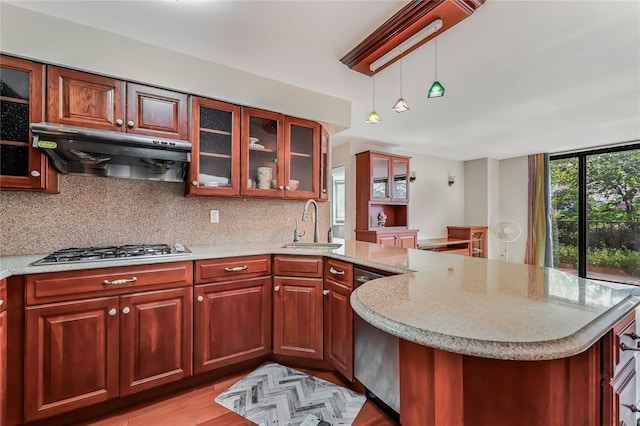 kitchen featuring sink, appliances with stainless steel finishes, hanging light fixtures, tasteful backsplash, and extractor fan