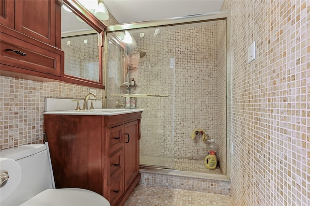 bathroom with vanity, toilet, an enclosed shower, and tile walls