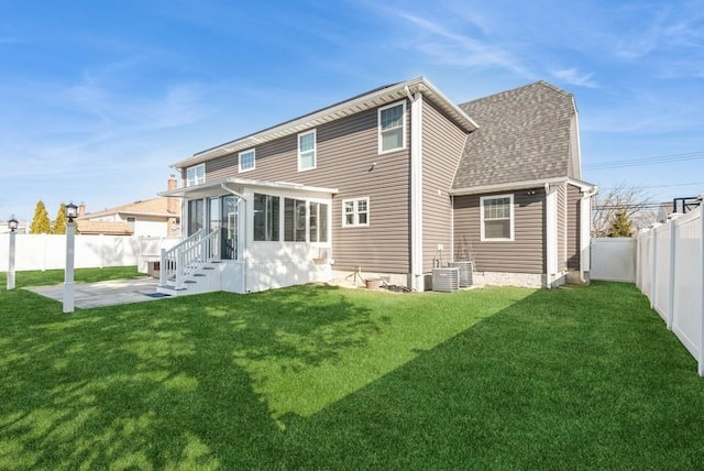 rear view of property featuring cooling unit, a lawn, a sunroom, and a patio area