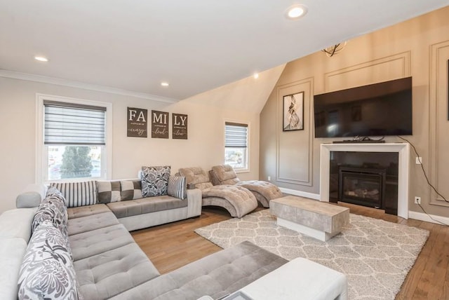 living room featuring crown molding, hardwood / wood-style flooring, and vaulted ceiling