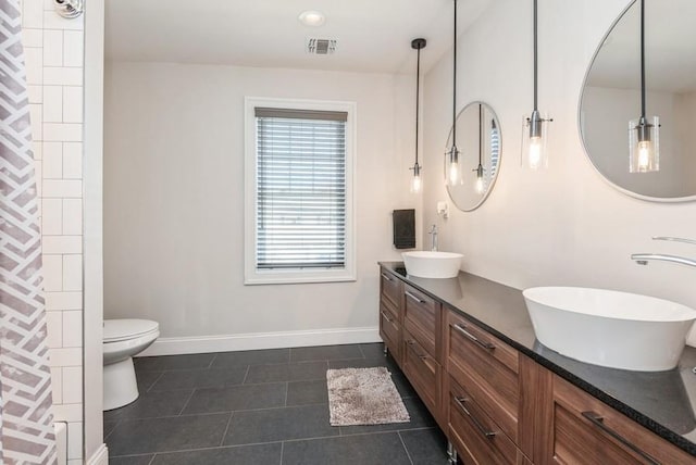 bathroom featuring vanity, tile patterned floors, and toilet