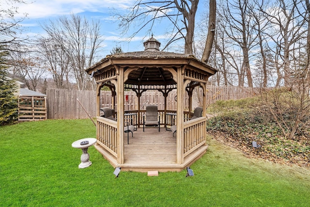 wooden deck with a lawn, a gazebo, and fence