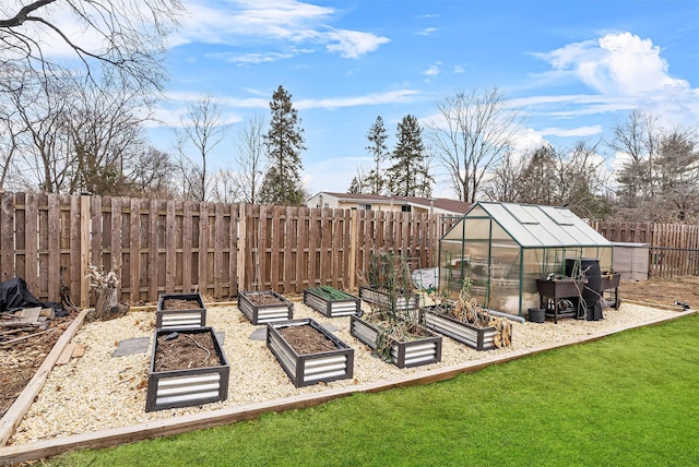 view of yard with an outbuilding, a fenced backyard, a greenhouse, and a vegetable garden