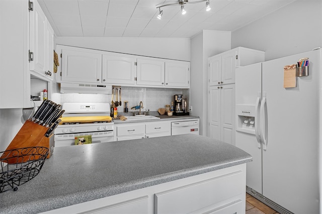 kitchen with under cabinet range hood, a peninsula, white appliances, a sink, and white cabinetry