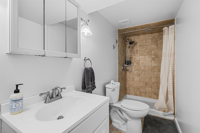 bathroom featuring visible vents, vanity, toilet, and tiled shower