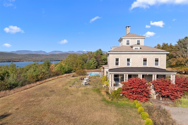 exterior space with a porch, a mountain view, and a yard