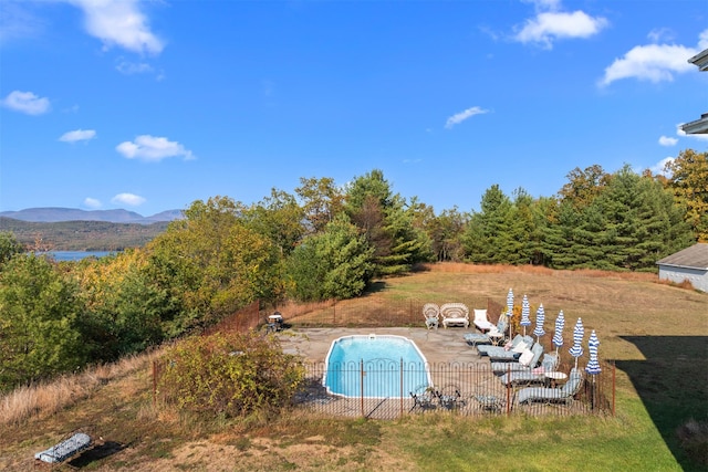 view of swimming pool featuring a patio, a mountain view, and a yard