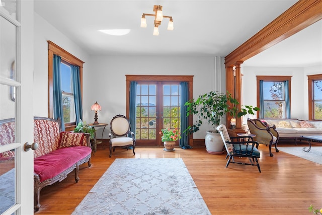 sitting room featuring light hardwood / wood-style floors, french doors, and ornate columns