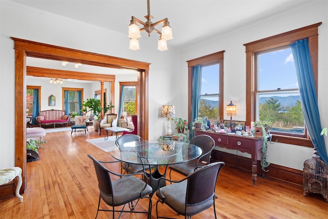 dining area featuring light wood-type flooring and an inviting chandelier