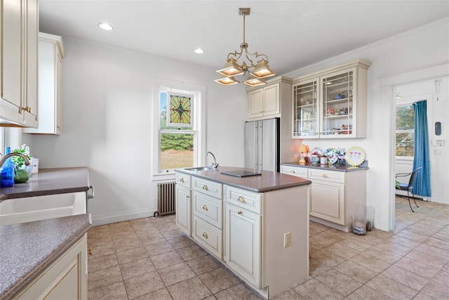 kitchen featuring high end fridge, sink, a center island, pendant lighting, and cream cabinetry