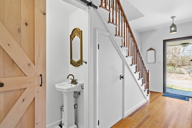 interior space with sink, light hardwood / wood-style flooring, and a barn door