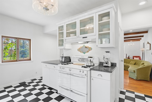 kitchen featuring range with two ovens, white cabinetry, and an inviting chandelier