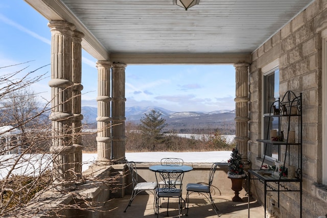 snow covered patio featuring a mountain view